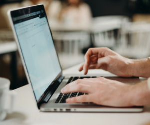 A person is typing on a laptop computer.